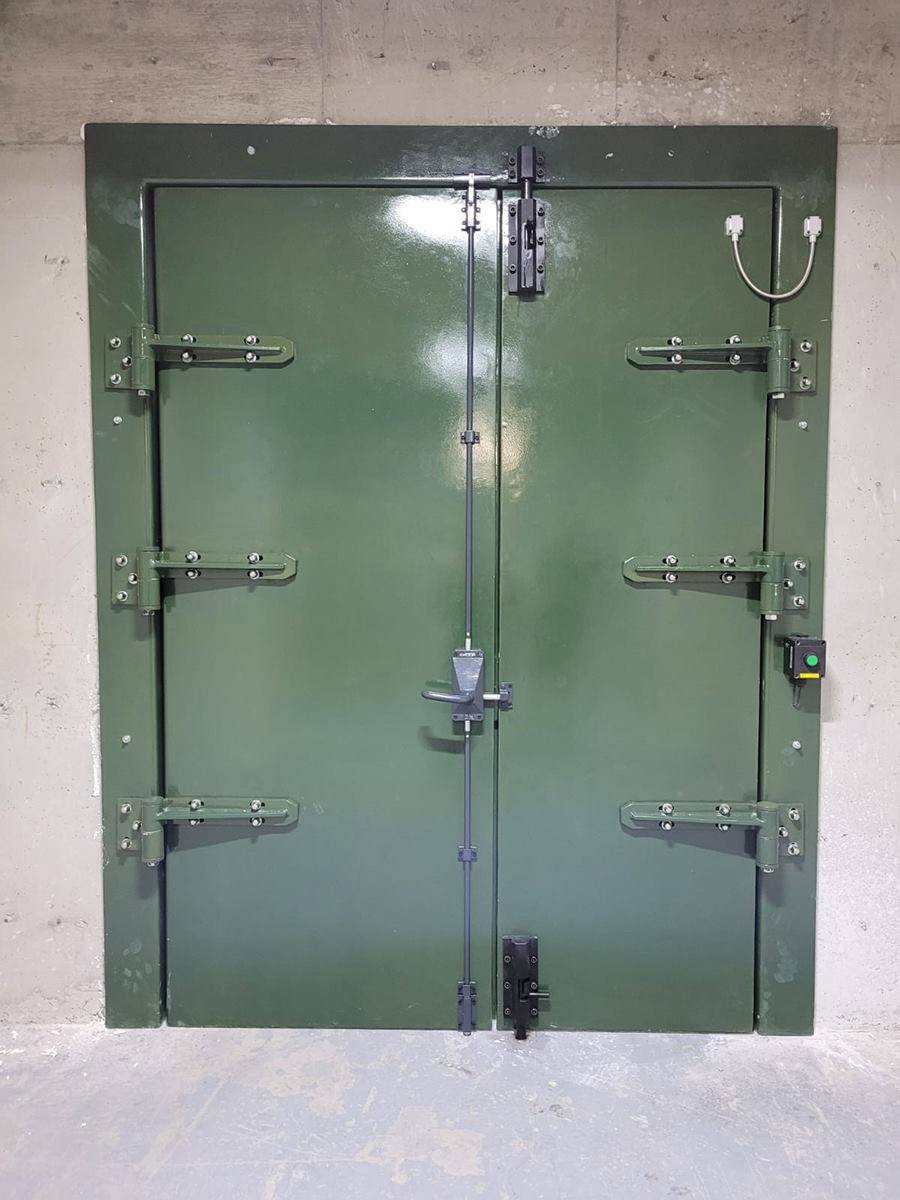 Twin-leaf heavy blast door with espagnolette locking, installed in a reinforced concrete opening
