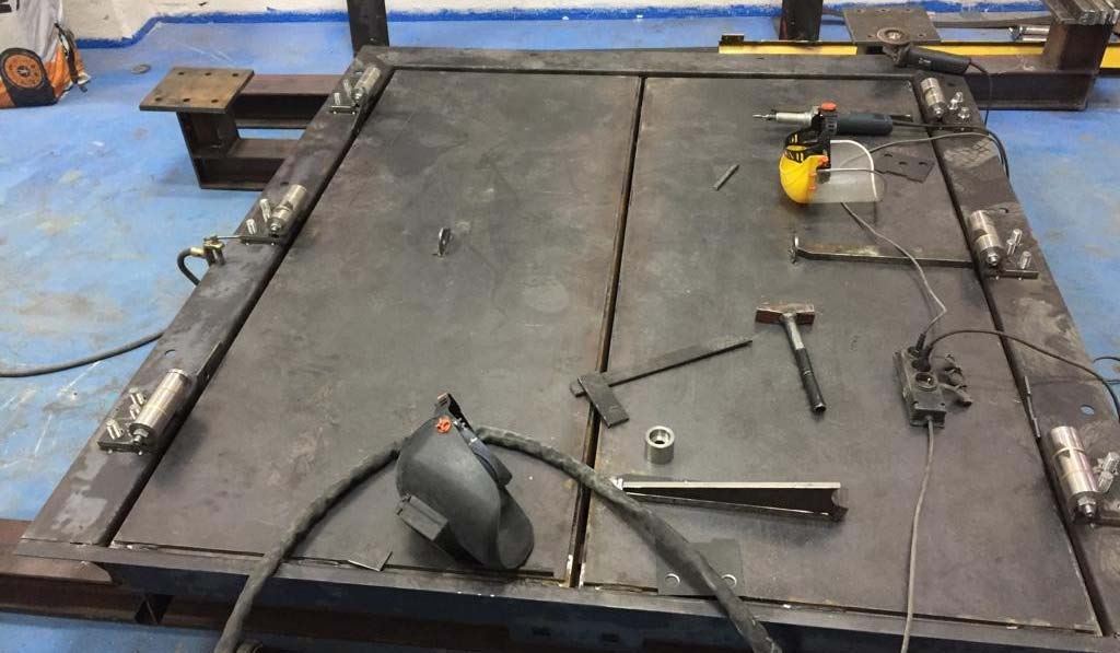 Heavy steel blast door leaf on the welding bench during in-house fabrication